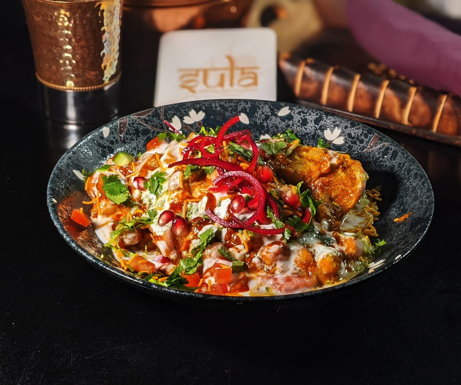 Samosa Chaat topped with chutneys, yogurt, and spices at Sula Indian Restaurant