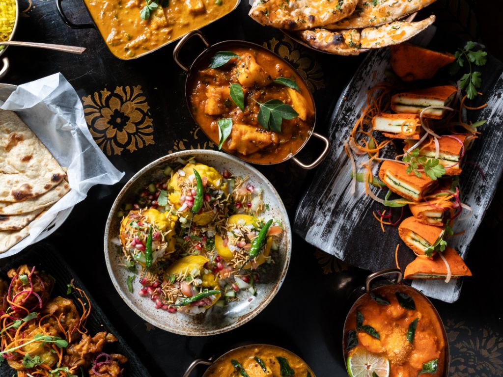 Freshly prepared Indian dishes served hot including curries rice and tandoori breads